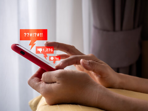 Close up of user receiving negative reactions and abusive messages on smartphone. Cyberbullying, online harassment, digital toxicity, social media pressure, and mental health impact in communication.