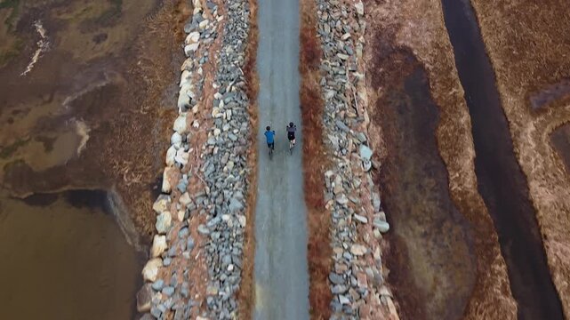 Aerial View Two Cyclists Riding Gravel Causeway Salt Marsh Trail Cole Harbour Heritage Park Halifax Nova Scotia Canada Ocean Inlet Coastal Landscape Active Lifestyle Outdoor Recreation Scenic Nature