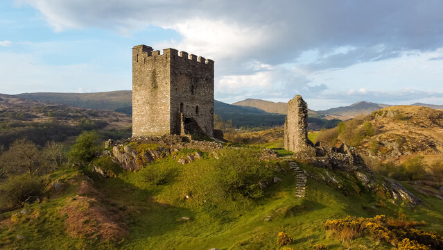 Aerial view of Dolwyddelan Castle perched on a rocky hilltop, its medieval keep and ruined walls bathed in morning light