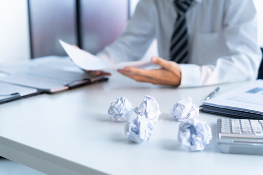 Businessman crumpled paper and throw on desk