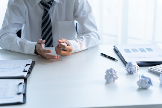 Businessman crumpled paper and throw on desk