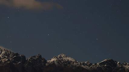 Fototapeta premium Starry Night Sky Over Snow Capped Mountain Peaks in Queenstown