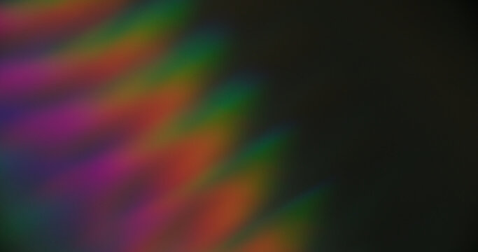 Defocused light. Colorful striped glow. Aged film art luminosity texture. Optical spectrum lines on dark black background free space.