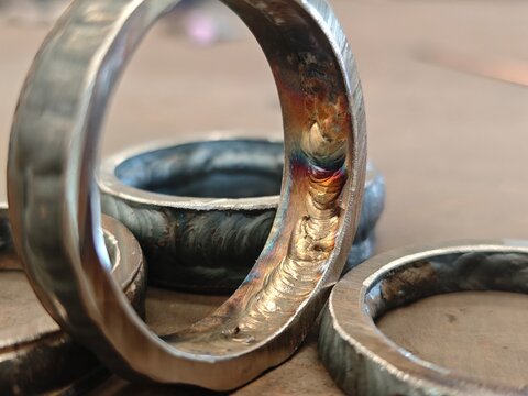 Close up of root pass weld with visible welding defect on metal ring joint. Industrial fabrication inspection concept showing poor weld penetration, flaw detection, and repair requirement.