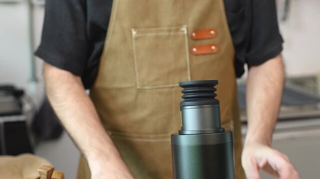Senior barista in an apron operates a coffee machine at his small business. man focus and experience reflect a lifestyle of independence, craftsmanship, and pride in daily work entrepreneurship
