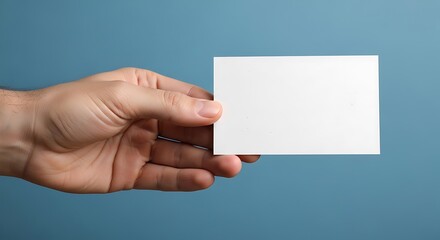 Obraz premium Hand Holding Blank White Business Card Mockup on Blue Background