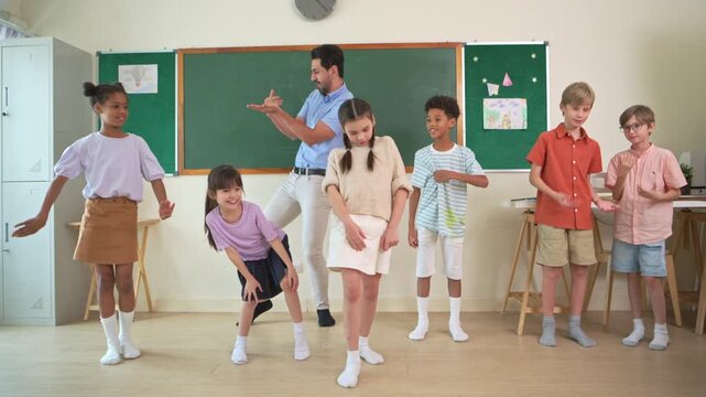 Diverse group of school children enjoying dance activity with teacher in an international classroom, encouraging active learning and teamwork