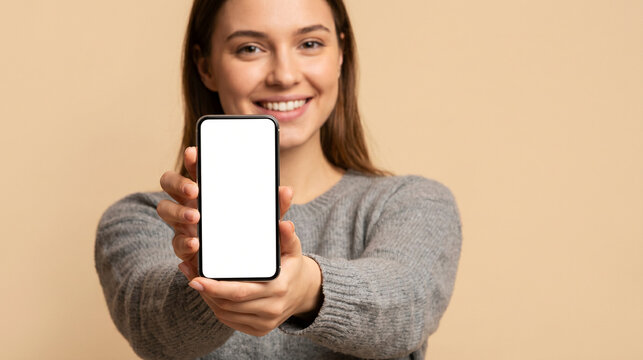 Smiling Young Woman Holding Up Smartphone with Blank Screen