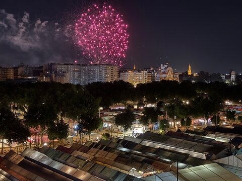 fireworks over the city Fireworks illuminating the sky over the Feria de Abril fairground in Seville, Spain. Night view with traditional tents and city skyline during the famous Andalusian festival.