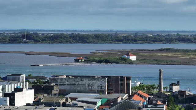 Telephoto shot of historic island with colonial building and pier in the Lagoa dos Patos estuary seen from Rio Grande waterfront