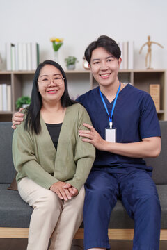 Asian man caregiver and woman patient smiling in home healthcare setting