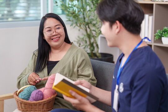 Asian healthcare professional engaging with woman patient knitting