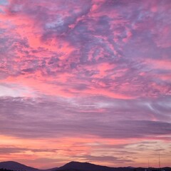 Obraz premium Pink Sunset Clouds Above Dark Mountain Landscape