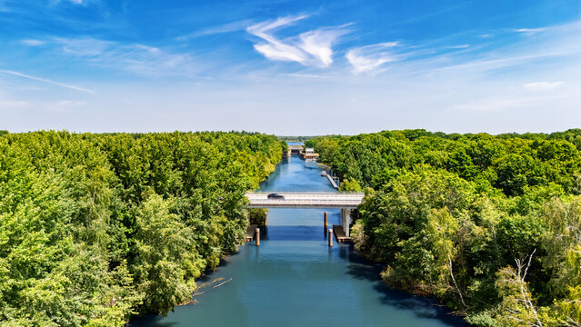 Aerial drone view of cars crossing bridge over river, forest landscape and modern road bridge, transportation and infrastructure in the Netherlands