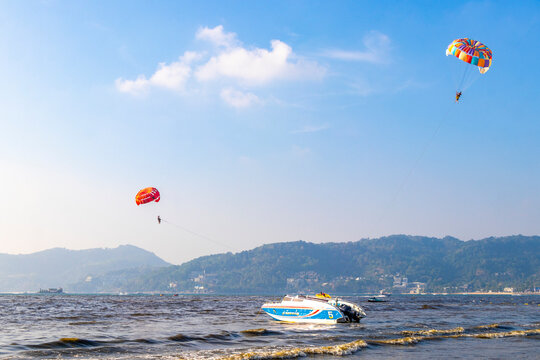 People tourism on parasailing parachute sport activity Patong Phuket Thailand.