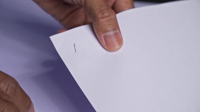 Person organizing and stapling paperwork from a top-down perspective showing office administration tasks