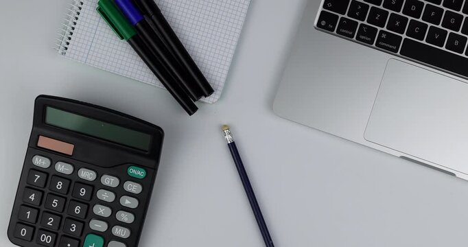 Organized desktop with technology and tools on white. A hand adds a pencil to the setup for study or business. Ideal for education and work concepts.