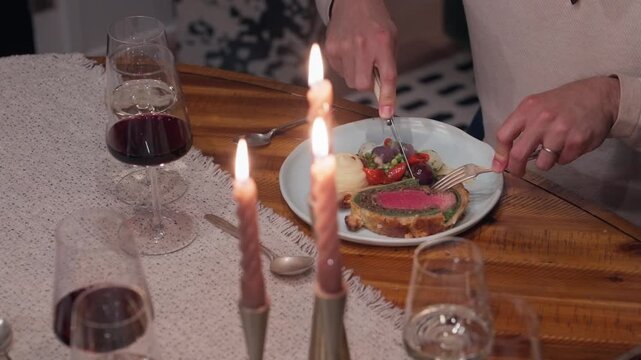 A rustic Beef Wellington dinner is enjoyed at the table of a private dining experience (slow motion 4K).