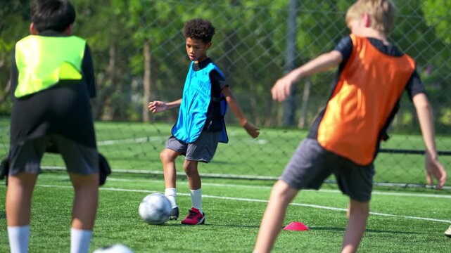 International school student practicing soccer dribbling on the field, improving ball control and individual skills in sports training