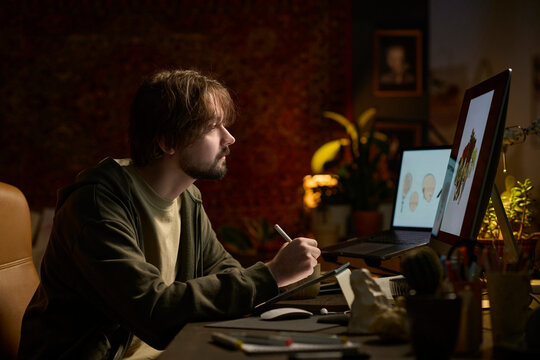Freelance illustrator drawing on graphics tablet in home office