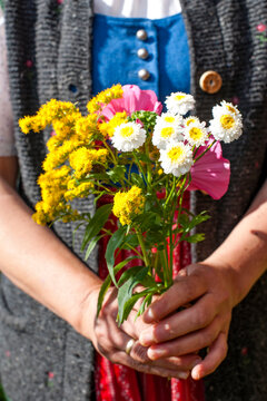 Holding a colorful flower bouquet on Salzburger Almenweg in Austria