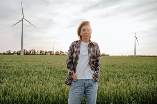 Beautiful woman with hands in pocket standing at field