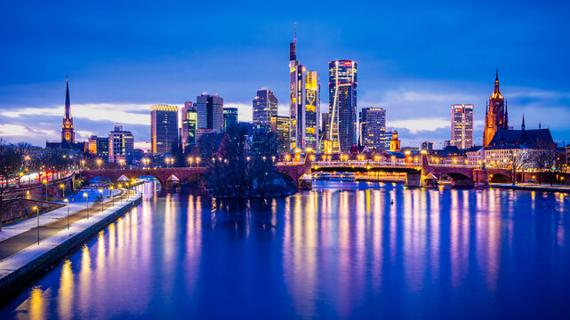 Illuminated Frankfurt am Main skyline and river reflection at night