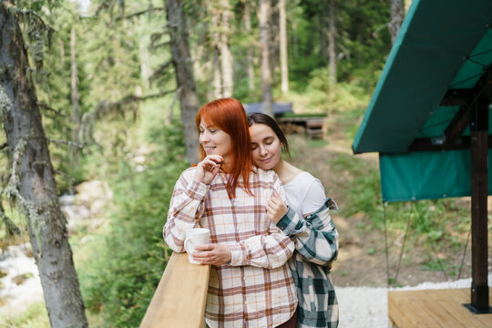 Happy friends hug on a glamping terrace in Sheregesh Siberia