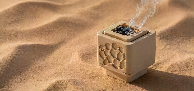 Traditional Arabic Bakhoor Incense Burner with Smoke on Desert Sand