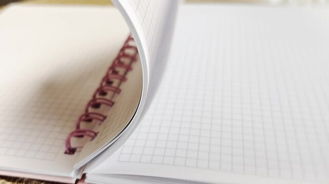 Flipping through white paper sheets in spiral notepad, ideal mockup for educational projects, student assignments, or personal diary and memo templates