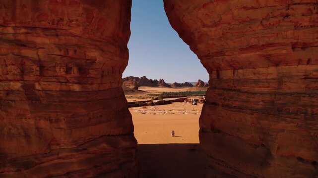 Tourists stand by the Elephant Rock in Saudi Arabia, AlUla. Sandstone rock in Arabic desert which is popular touristic destination