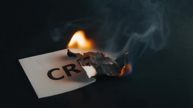Burning paper with the word crisis symbolizing danger and emergency concept in dark background