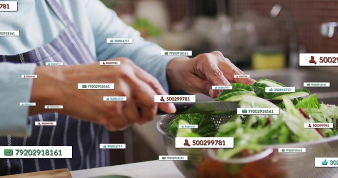 Slicing senior-Indian making salad in kitchen wearing apron holding knife over colander with tags