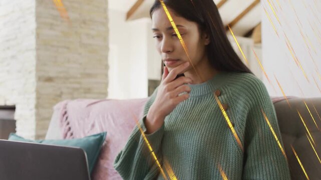 Woman glancing at laptop, raising hand and fixing hair, settling into studying with golden overlay