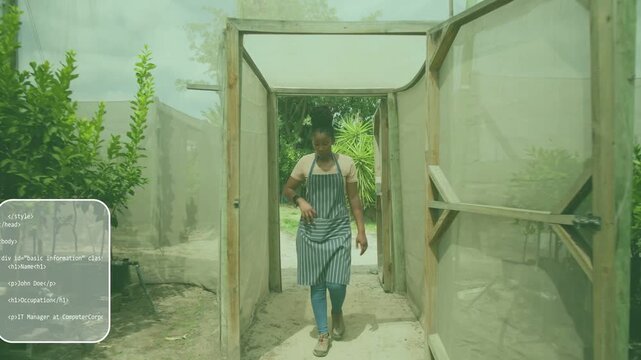 Nursery worker stepping through gate checking watch pulling phone taking call walking past saplings