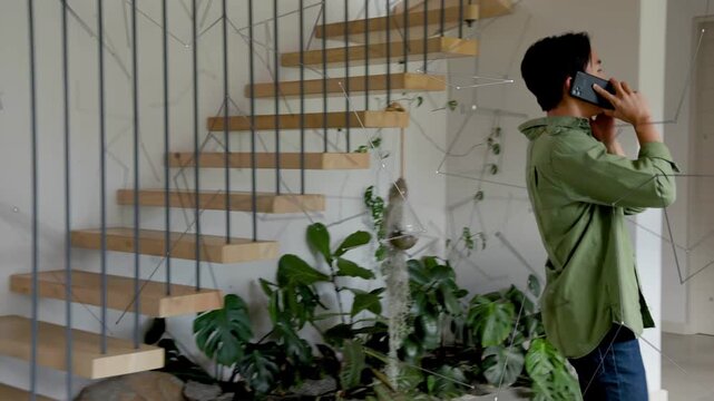 Man taking call, speaking while walking through home office, animated cues guiding laptop work