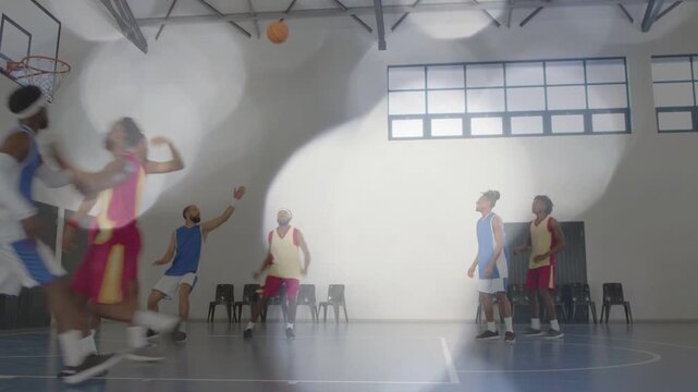 Male basketball team after blue player dribbling, red player shooting to score, bokeh drifting