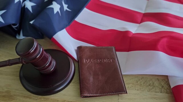 Passport and gavel placed on a table next to American flag during a legal discussion or travel planning moment