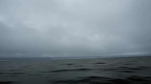 Moody ocean horizon with overcast grey sky and gentle rolling waves cloudy