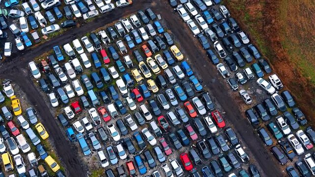 Top down view of abandoned vehicles in salvage yard. Rows of damaged cars for recycling at a professional junkyard.