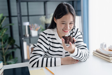 Fototapeta premium Asian Woman Engaging with Voice Assistant on Smartphone in Modern Home