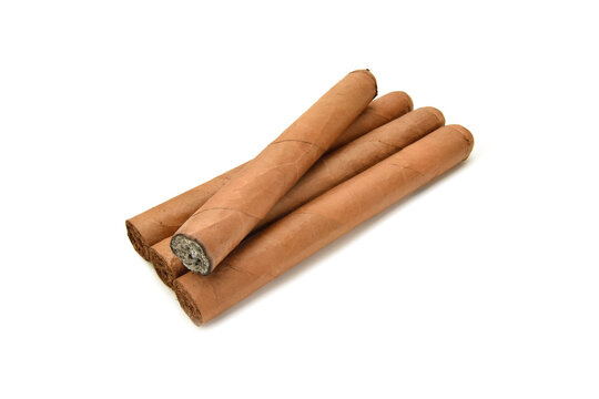 Brown tobacco long cigars in a group with burned one and grey ash closed up isolated on white