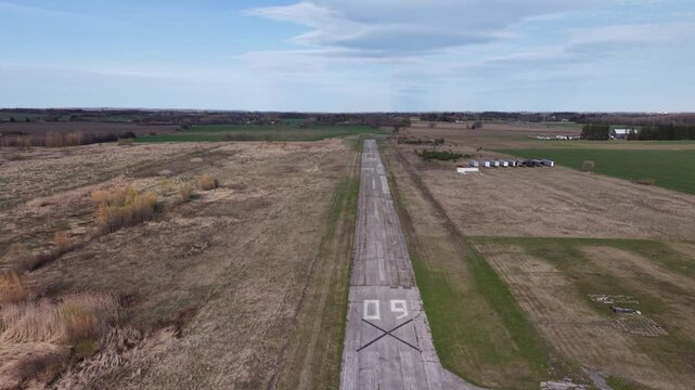 Drone shot flying the length of the abandoned asphalt runway 09 at the decommissioned Toronto Markham Airport (CNU8) in Ontario, featuring visible closure 'X' markings