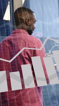 Vertical video: Analyst raising marker, writing on glass, animated charts layering for business