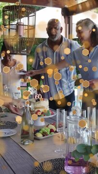 Vertical video: Host standing, guests clapping, cohost serving cake for event, hex bokeh over scene