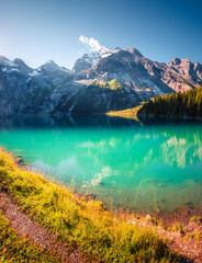 The most gorgeous Swiss lake Oeschinensee surrounded by grand mountains. Location Bernese Oberland, Switzerland, Europe. Photo wallpaper. © Leonid Tit