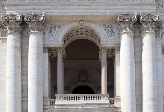 Dettaglio della loggia centrale e delle colonne corinzie della facciata di San Giovanni in Laterano a Roma, maestosa architettura tardo barocca con capitelli decorati e balaustra in marmo