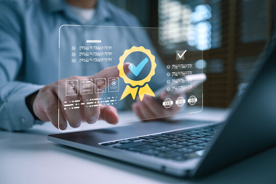 Business professional using laptop with digital certification badge, quality approval checklist, compliance documents, verification interface, and trusted standard management for corporate assurance.