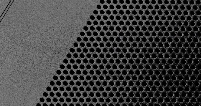 Black perforated surface texture.  Dark perforated surface with a repeating hole pattern, creating a textured and industrial look.