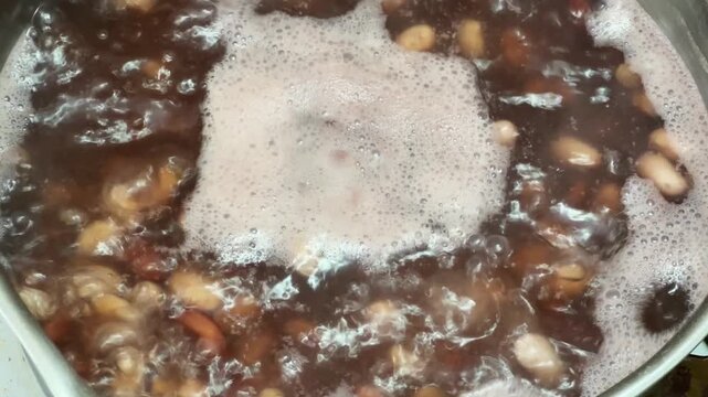 Boiling of white and red kidney beans in cooking pot
